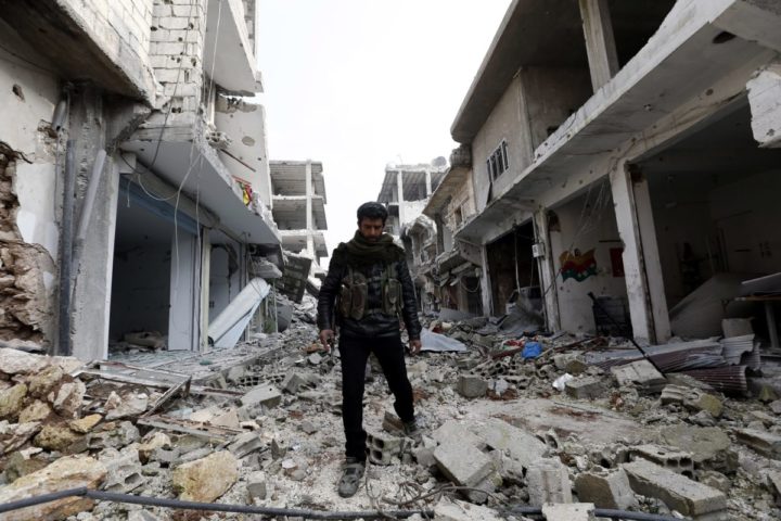 2015-01-28 14:01:02 epa04590715 A member of Syrian Kurdish People's Defence Units (YPG) walks through rubbles at a street in Kobane, Syria, 28 January 2015. According to reports Kurdish fighters on 26 January claimed to have pushed militants from the group calling themselves the Islamic State (IS) out of the embattled Syrian town of Kobane, following four months of fighting, which included airstrikes carried out by an international anti-IS coalition. EPA/SEDAT SUNA