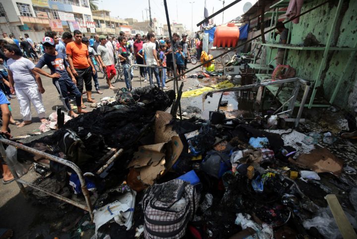 2016-05-11 23:11:14 Iraqis look at the damage following a car bomb attack in Sadr City, a Shiite area north of the capital Baghdad, on May 11, 2016. / AFP PHOTO / AHMAD AL-RUBAYE
