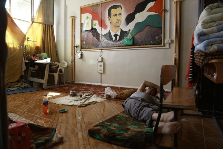 2016-09-16 11:27:19 A man suffering from a mental disorder lies under a portrait of the Syrian president at a school used as shelter by displaced families fleeing the Islamic State (IS) group, on September 16, 2016, in the Kurdish-majority northeastern city of Qamishli. Qamishli is under the shared control of the Syrian regime and Kurdish authorities, who have declared zones of "autonomous administration" across parts of north and northeast Syria. / AFP PHOTO / DELIL SOULEIMAN