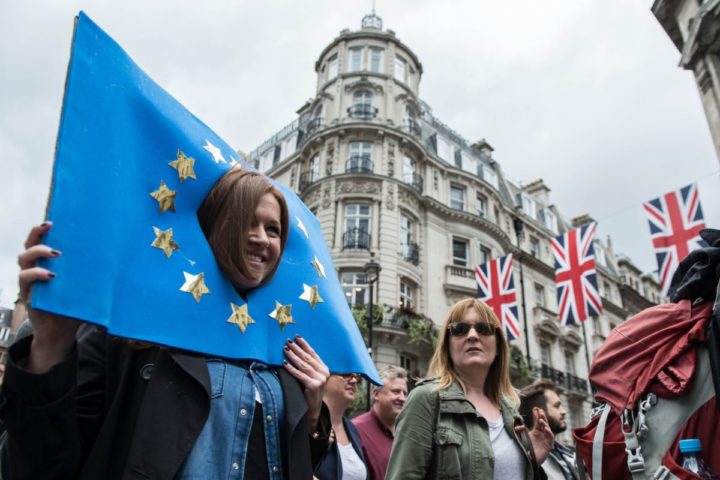 2016-07-02 12:43:32 A woman with her head, through a placard of the flag of Europe is pictured in the crowd as thousands of protesters take part in a March for Europe, through the centre of London on July 2, 2016, to protest against Britain's vote to leave the EU, which has plunged the government into political turmoil and left the country deeply polarised. Protesters from a variety of movements march from Park Lane to Parliament Square to show solidarity with those looking to create a more positive, inclusive kinder Britain in Europe. / AFP PHOTO / CHRIS J RATCLIFFE