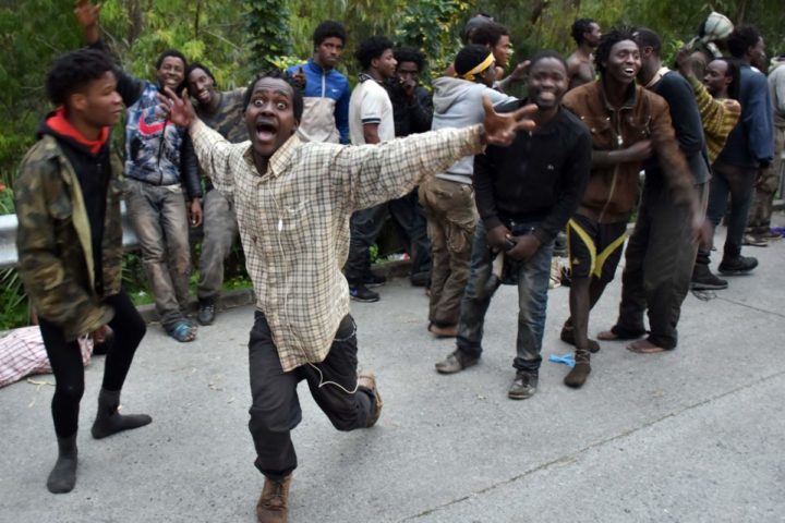 2017-02-17 07:16:54 TOPSHOT - Migrants celebrate outside the Center for Temporary Stay of Immigrants (CETI) after forcing their way through a fence between Morocco and the tiny Spanish enclave of Ceuta on February 17, 2017. Hundreds of migrants stormed the border between Morocco and Spain at Ceuta today, days after Morocco warned the EU of fresh migrant trouble failing progress over a trade deal. / AFP PHOTO / Antonio SEMPERE