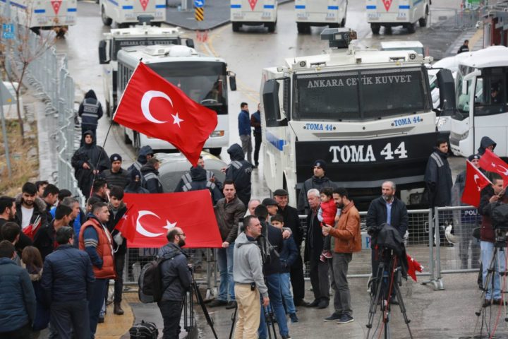 2017-03-12 10:00:43 Turkish residents waving their na tional flag gather by a blockade of anti-riot police vehicles and a sealed off area surrounding the Dutch consulate on March 12, 2017 in Ankara, for "security reasons" as a crisis escalated between Turkey and The Netherlands after Turkey's Foreign minister was barred from speaking in the country to promote a referendum at home. Turkish President Recep Tayyip Erdogan on March 12 warned the Netherlands it would pay a price for preventing top ministers from holding rallies ahead of a referendum on expanding his powers, as a crisis escalated with Turkey's key EU partners. / AFP PHOTO / ADEM ALTAN